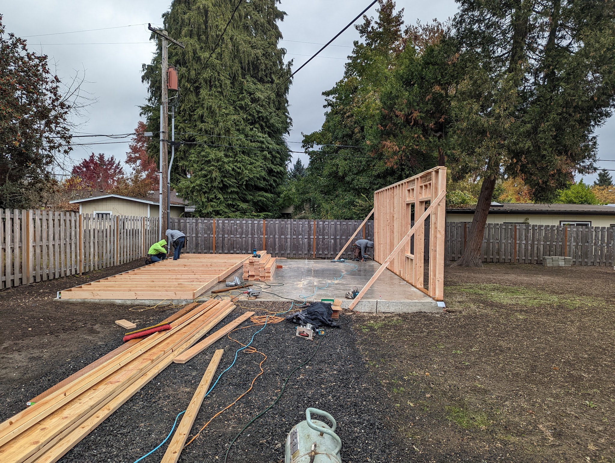 Crew framing a slab foundation structure in a backyard